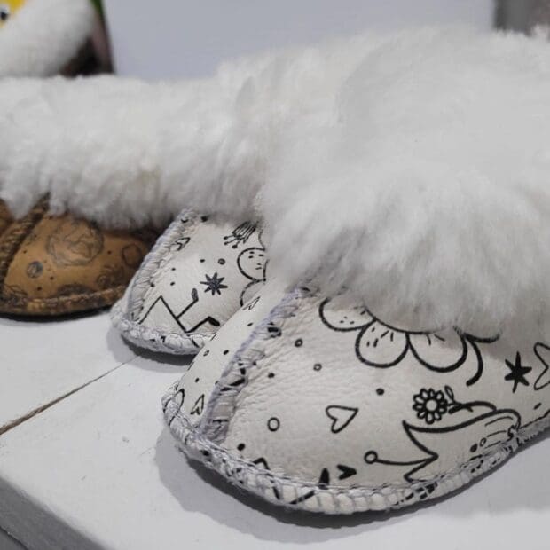 Cute sheepskin slippers for babies with heart and cupcake designs.